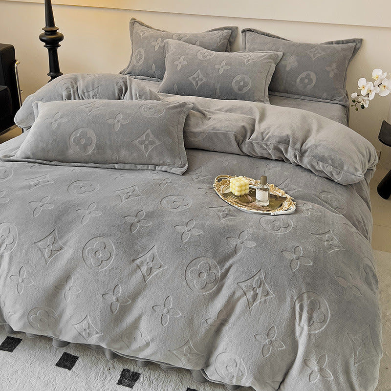 Gray textured bedding set with decorative pillows on a bed.