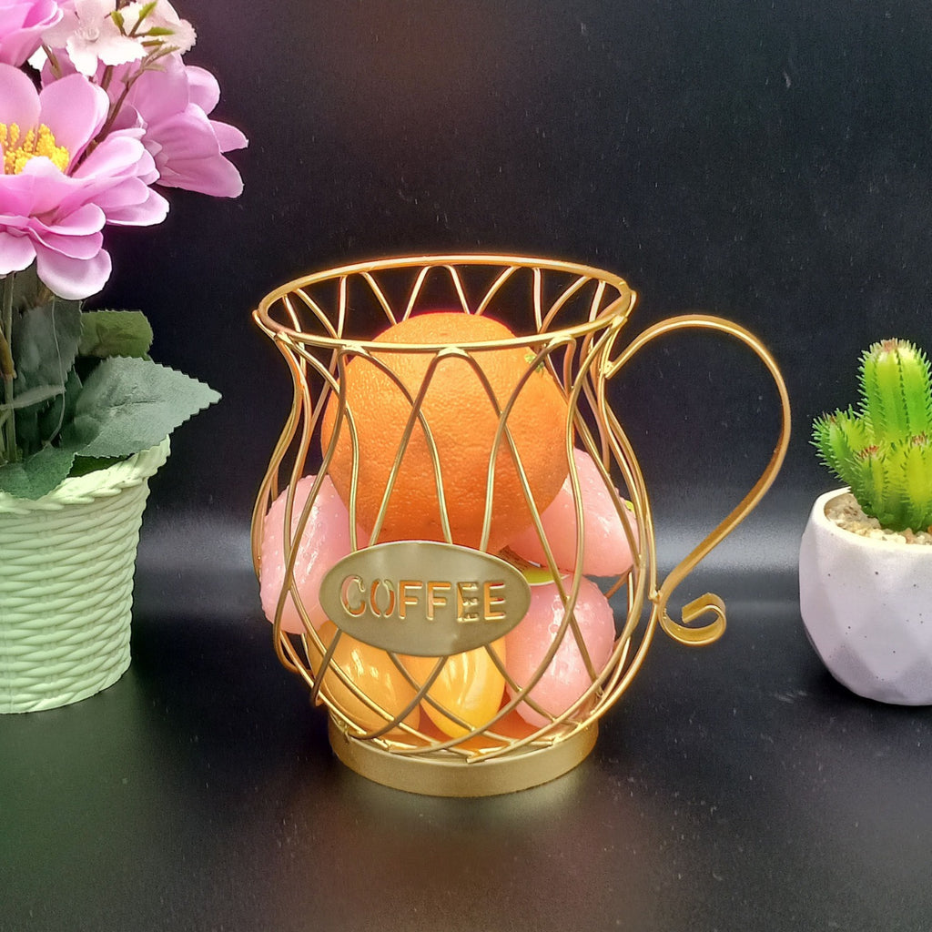 Decorative metal  coffee capsules holder with pink flowers and a lit candle on a dark surface.