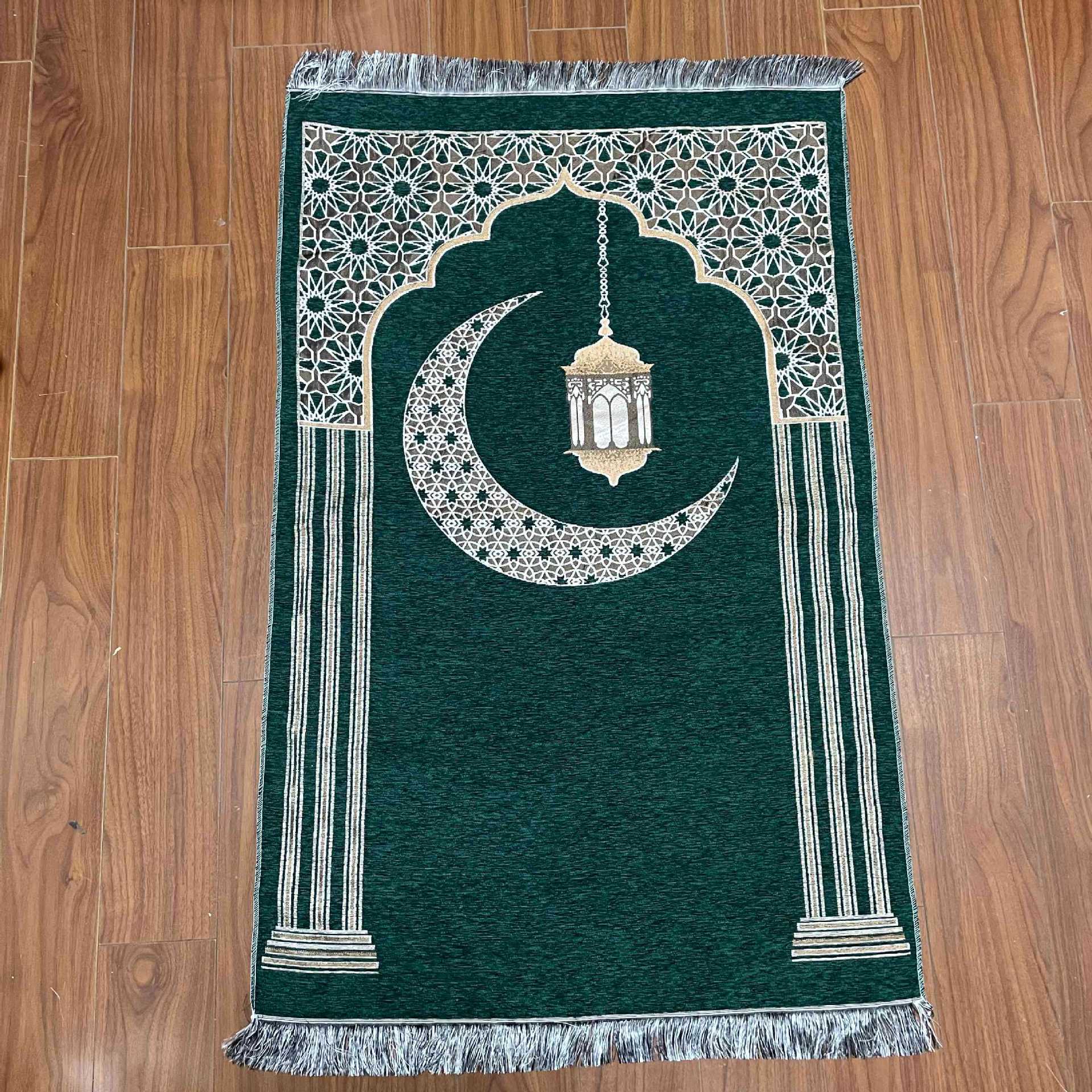 Green prayer mat with white crescent moon and lantern design on a wooden floor.