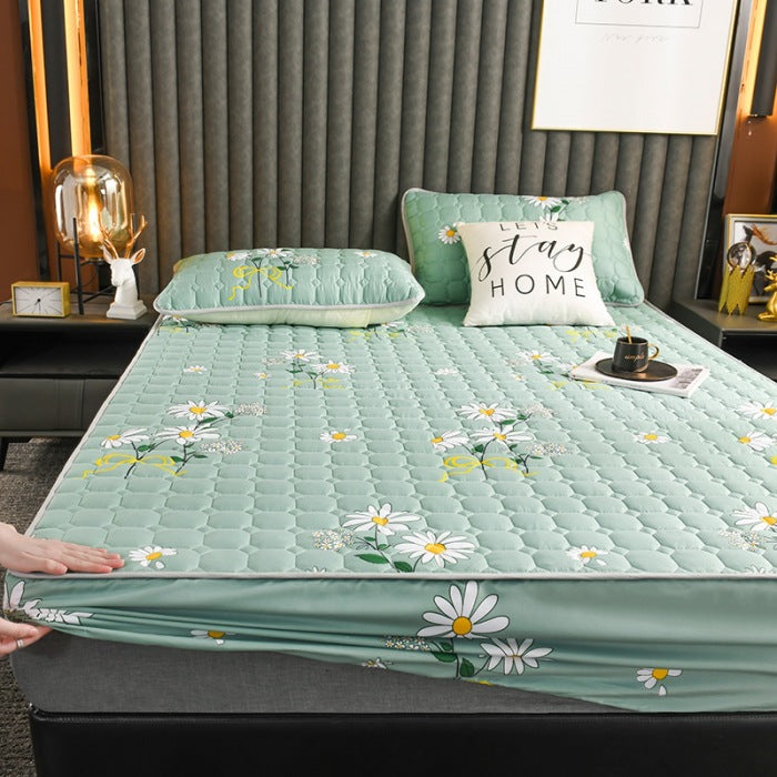Floral patterned mattress cover being fitted onto a bed in a bedroom setting.