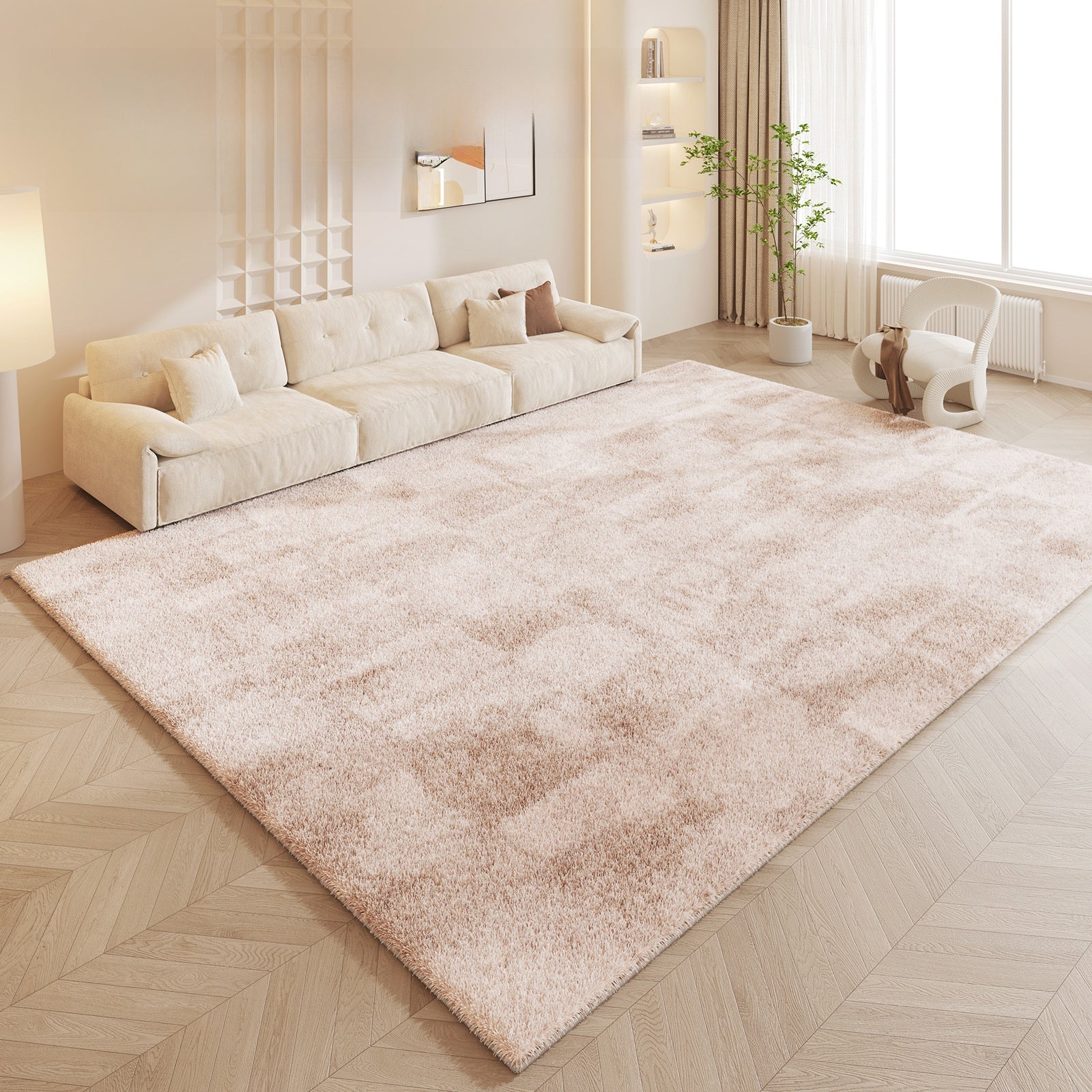 Beige area rug in a living room with a beige sofa and wooden floor.