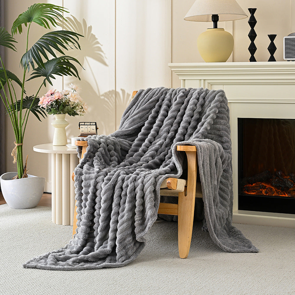 Gray blanket draped over a wooden chair in a cozy living room with a fireplace and plants.
