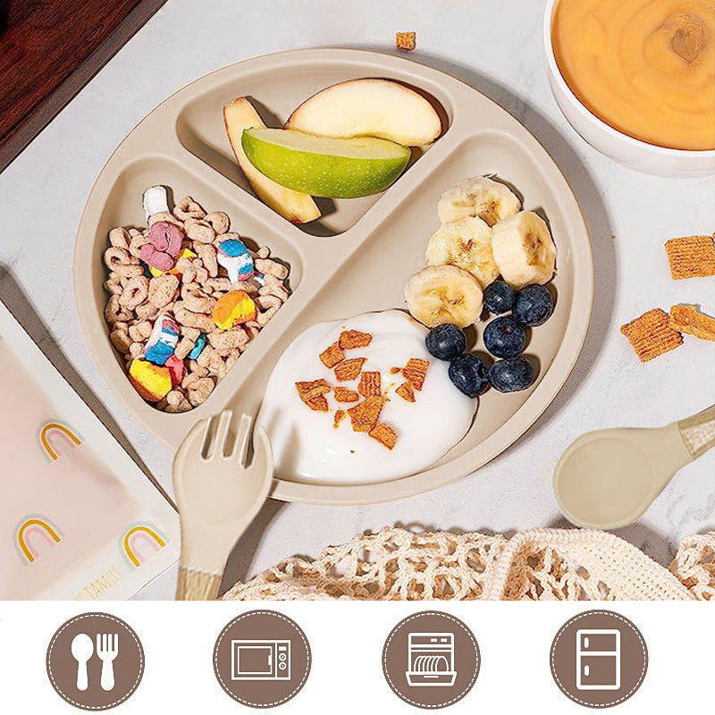 Children's plate with divided sections containing various foods on a light surface.