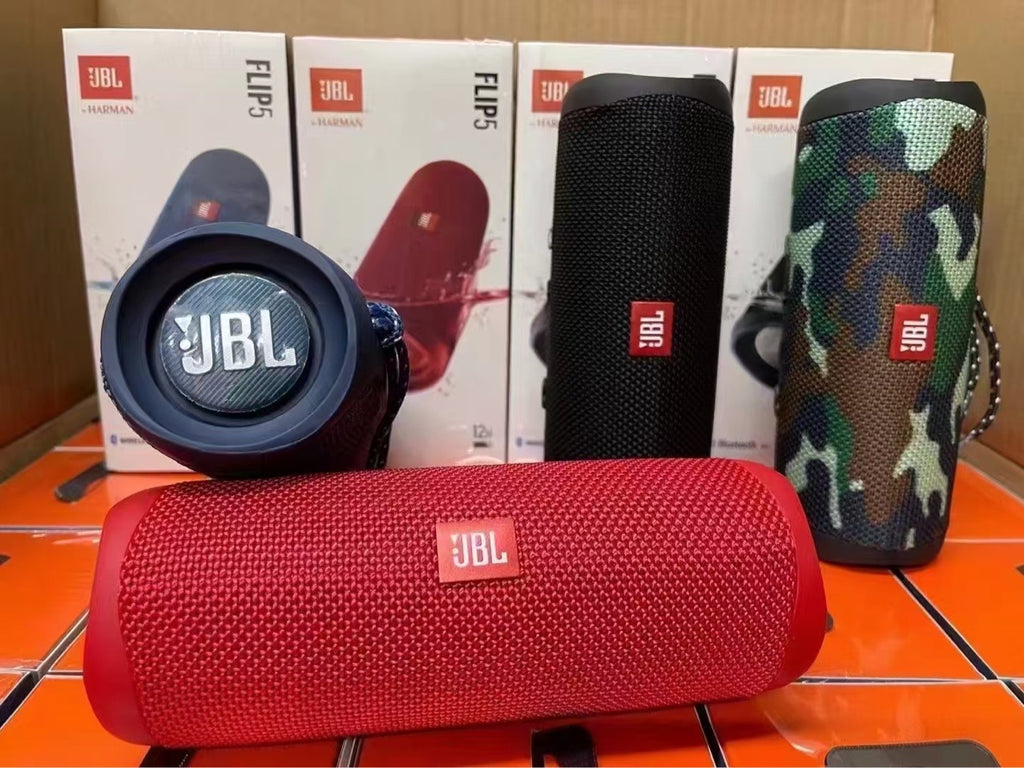 Red JBL speaker with blue, black, and camouflage covers in front of JBL boxes on a tiled floor.