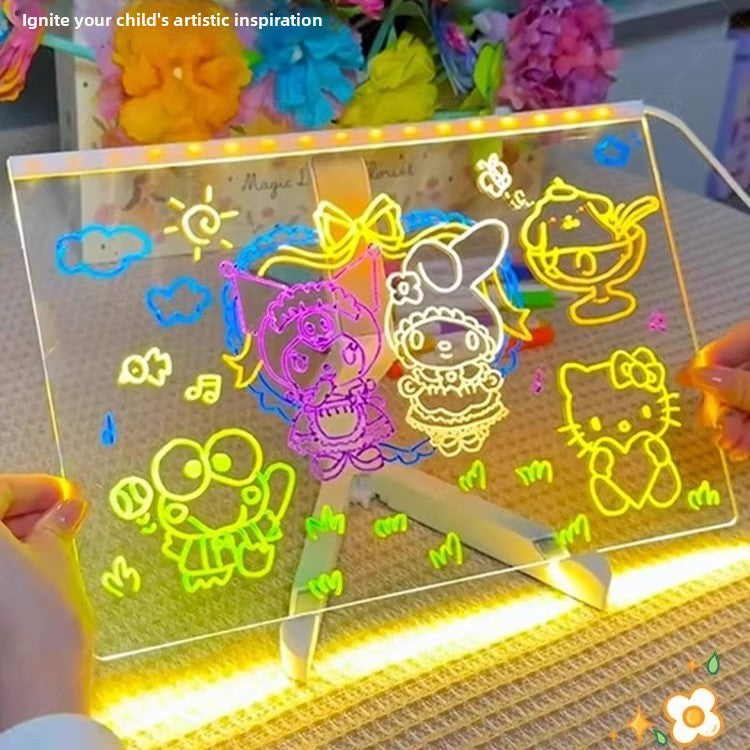Glowing colorful drawings on a transparent board with a pen, set against a blurred background of flowers and toys.