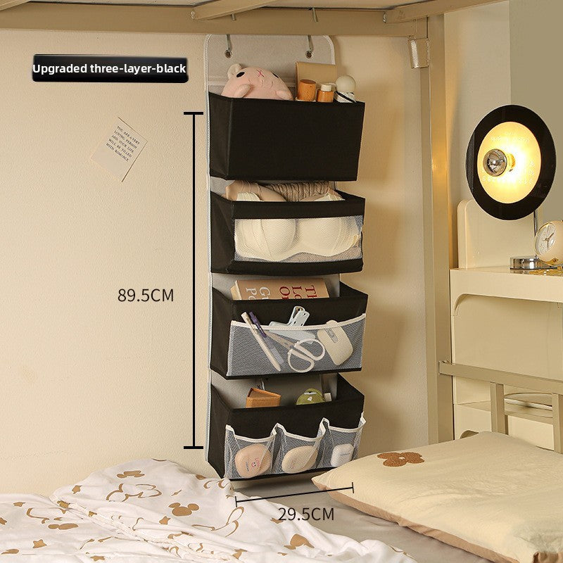 Three-layer black storage shelf with various items in a room setting.