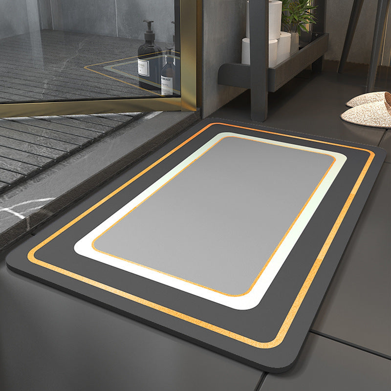 Gray bath mat with black border and yellow trim on a bathroom floor.