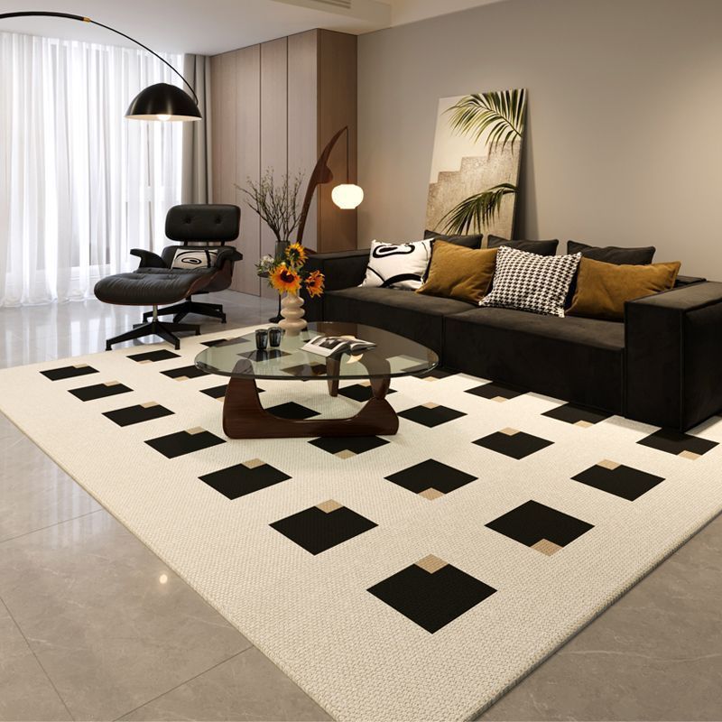 Modern living room with a checkered rug, sofa, and decorative items.