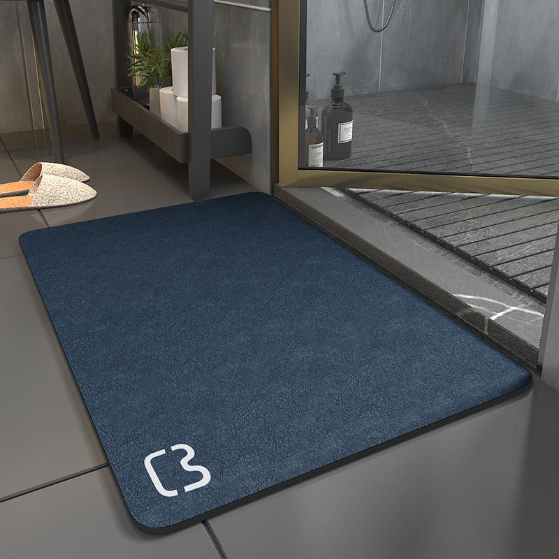 Blue mat with a logo on a tiled floor next to a glass door.