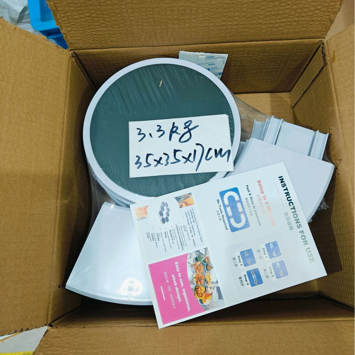 Product packaging with a round green component and printed materials inside a cardboard box.