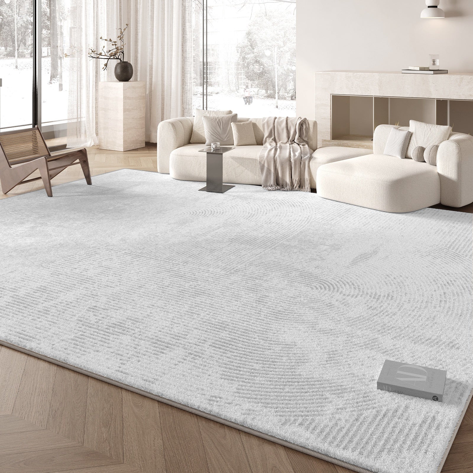 Living room with a large white rug, sofa, and decorative items.