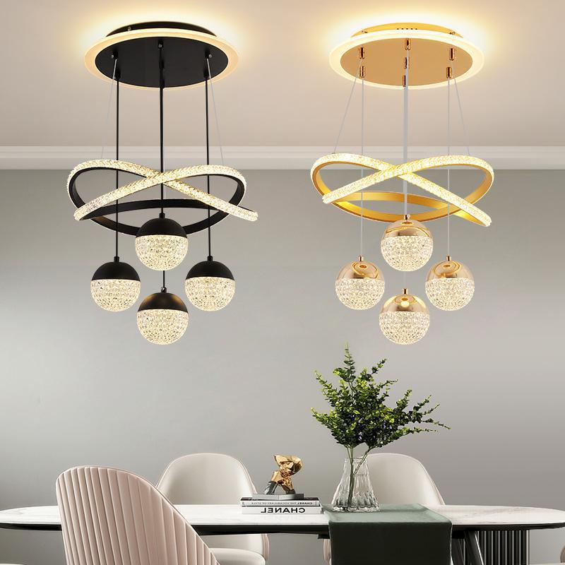 Two modern pendant lights hanging above a dining table with decor items.