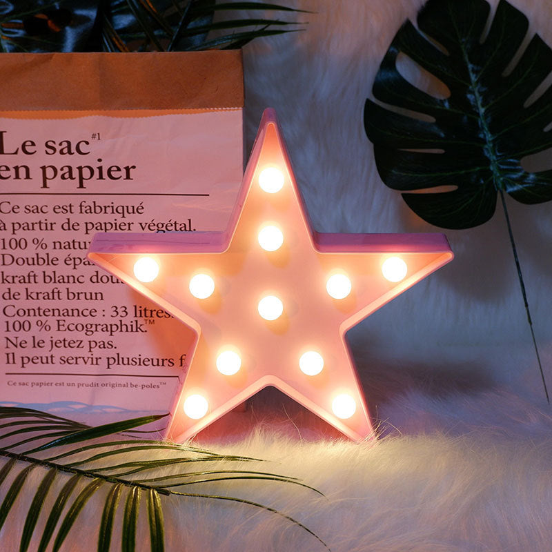 Star-shaped light fixture on a fluffy white surface with green leaves