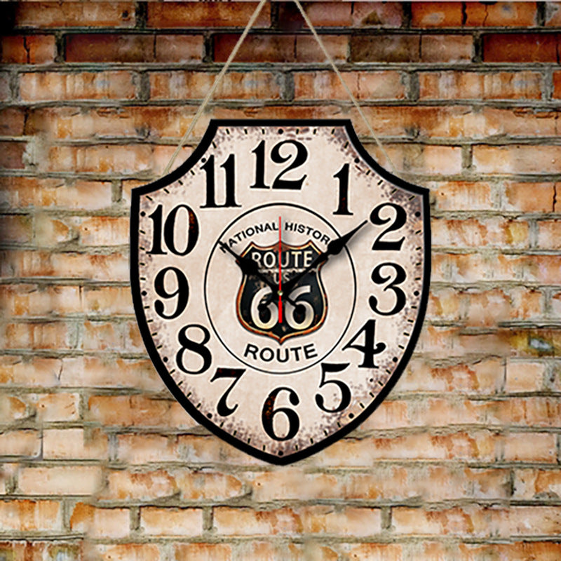 Vintage-style clock with Route 66 design on a brick wall.