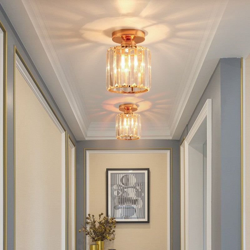 Two gold ceiling lights in a room with framed pictures and decor.