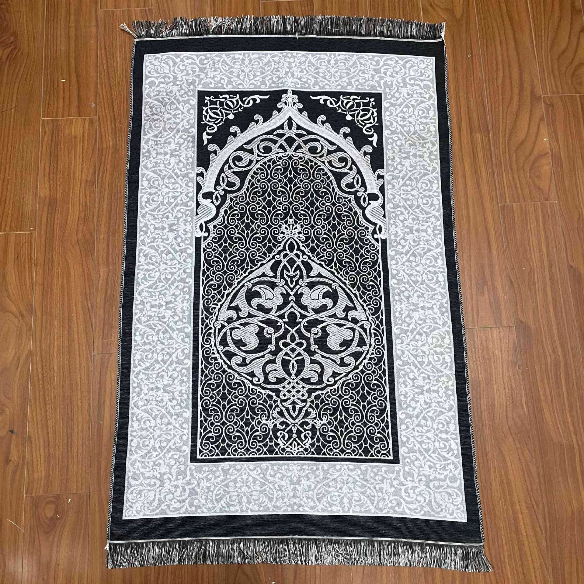 Decorative mat with intricate black and white design on a wooden floor