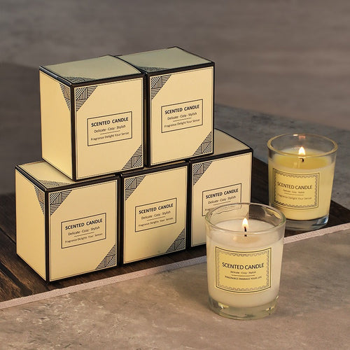 Set of scented candles with packaging on a textured surface