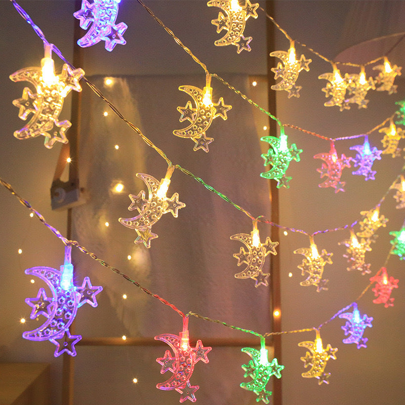 String lights with moon and star designs on a blurred background