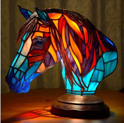 Colorful stained glass horse head lamp on a wooden surface with a dark background