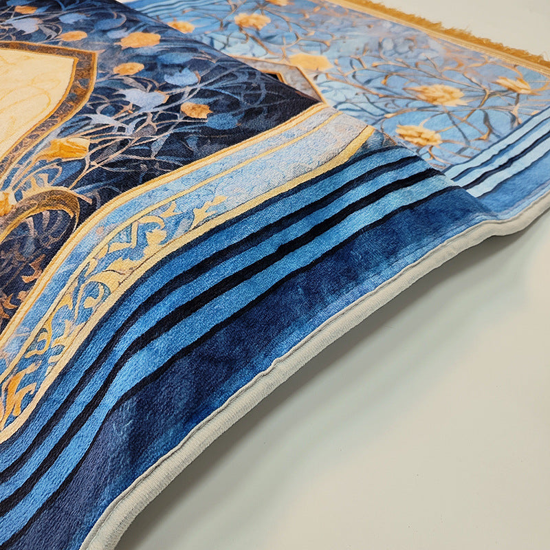 Close-up of a blue and gold patterned fabric with intricate designs on a light background
