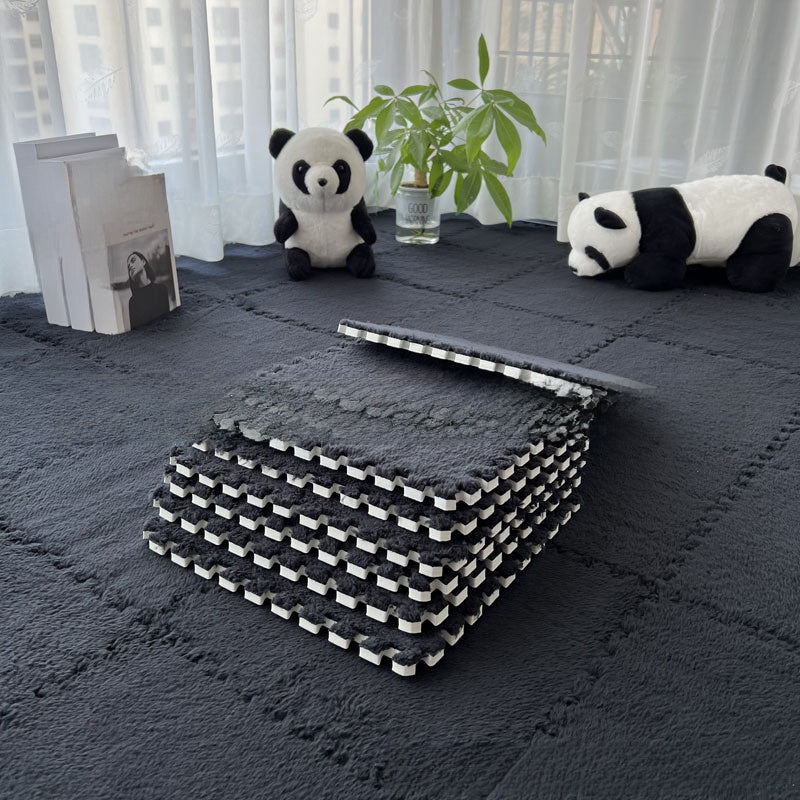 Stack of gray interlocking foam mats on a dark surface with panda decorations and a plant.