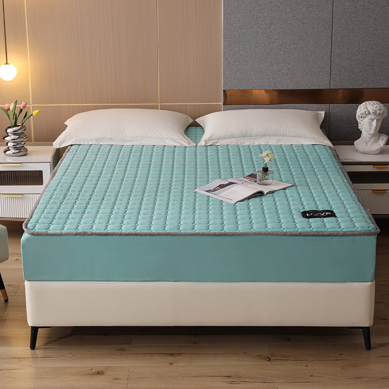 Blue mattress cover on a bed in a bedroom setting with decor elements.