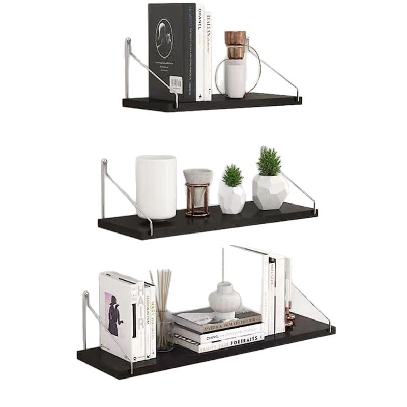 Set of black wall shelves with decorative items on a white background