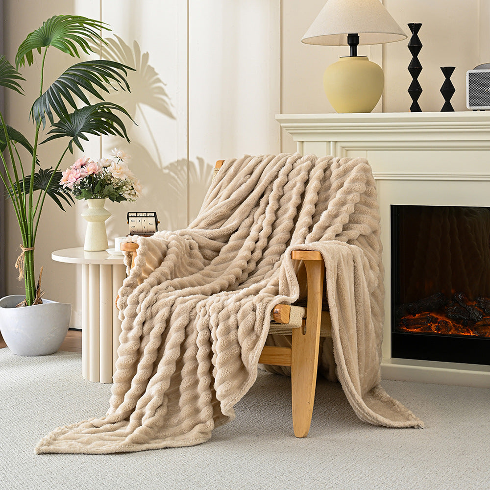 Beige blanket draped over a wooden chair in a cozy living room with a fireplace.