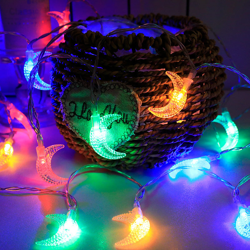 Decorative string lights with moon and star designs on a woven basket.