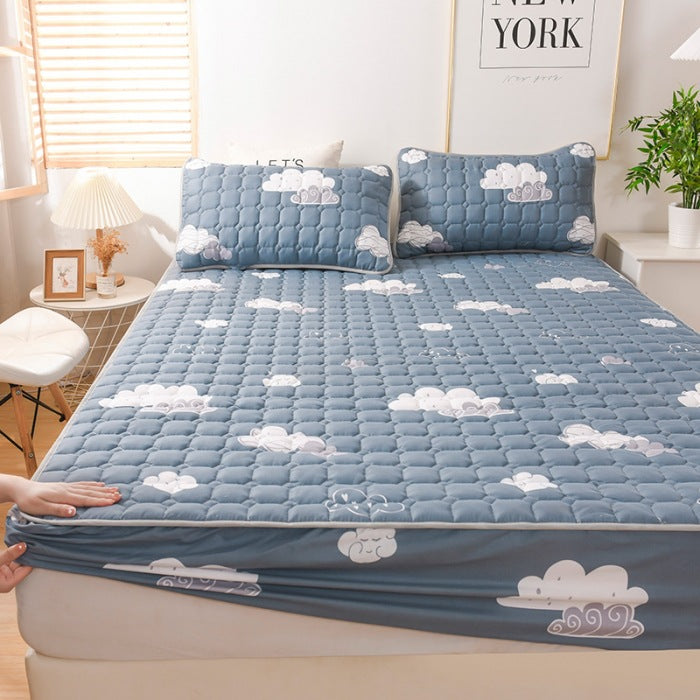 Blue cloud-patterned mattress cover on a bed in a bedroom setting.