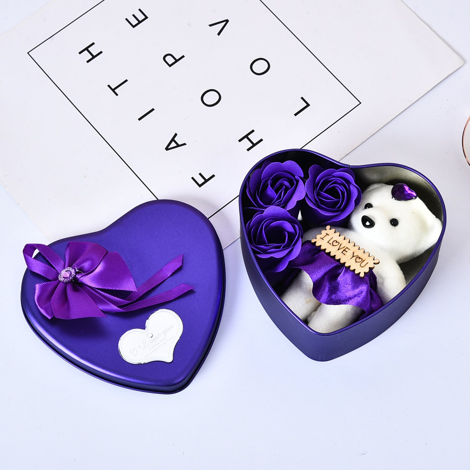 Heart-shaped purple box with a white bear and purple flowers on a light gray background