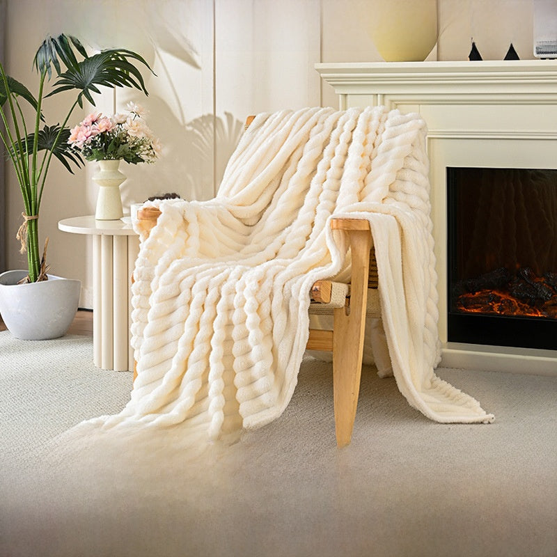 White textured blanket draped over a wooden chair in a cozy living room with a fireplace.