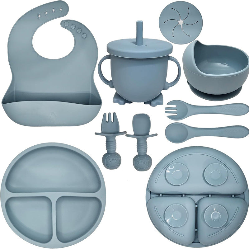 Collection of blue baby feeding utensils including a bib, cup, bowl, and various other items on a white background.