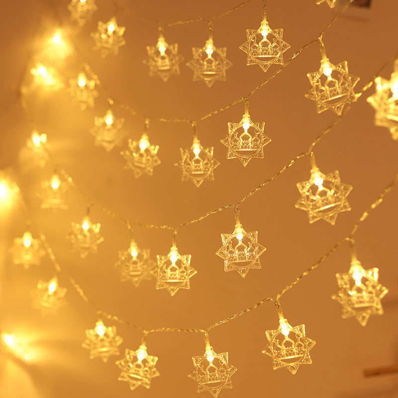String of decorative lights shaped like stars on a warm yellow background