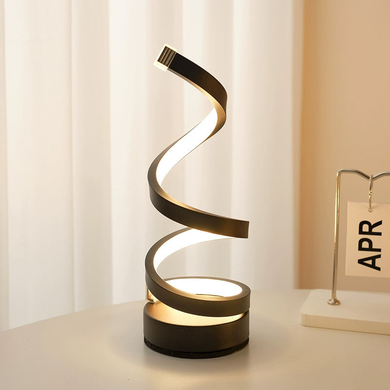 Modern spiral table lamp on a white surface with a light background