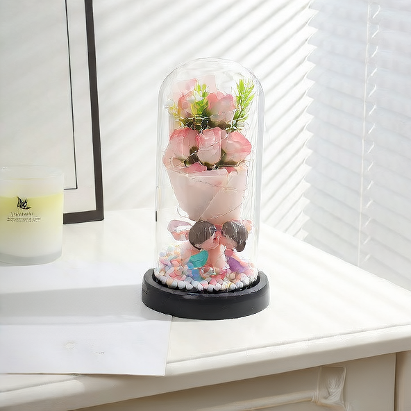 Decorative figure in a glass dome on a shelf with a candle and framed picture in the background.