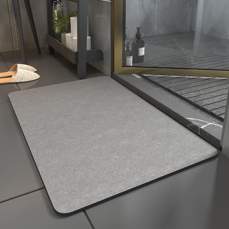 Gray mat on a tiled floor with a glass door in the background