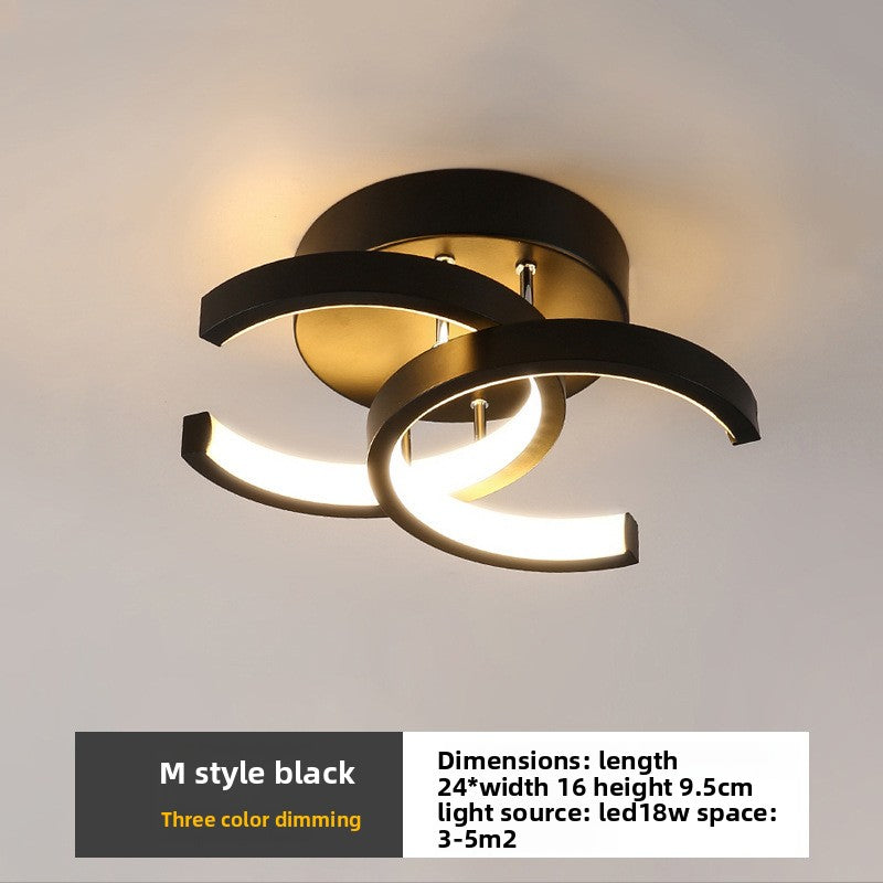 Modern ceiling light fixture with black and gold design on a neutral background