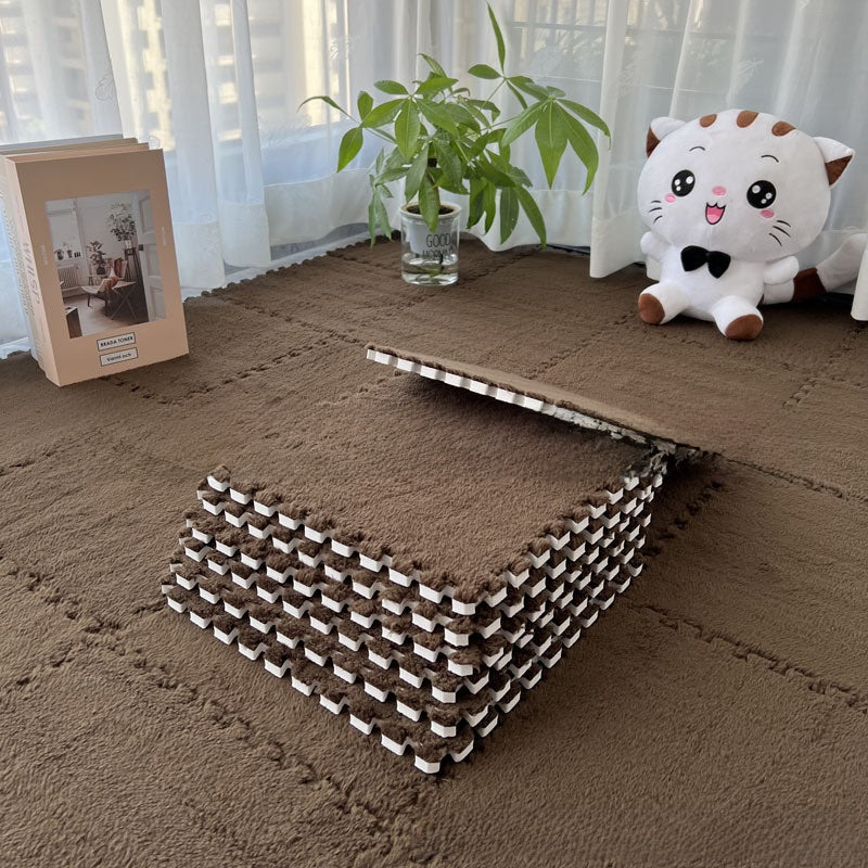 Brown interlocking foam mats with a cat plush toy and plant in a room.