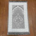 Decorative prayer mat with intricate patterns on a wooden floor