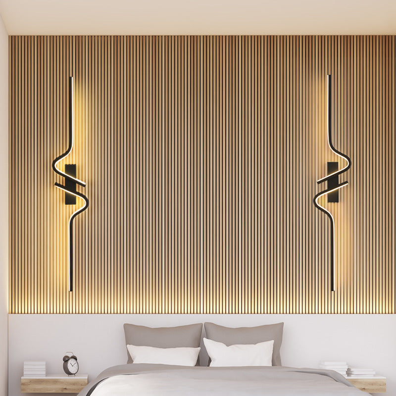 Modern bedroom with wooden paneling and wall lights above a bed.
