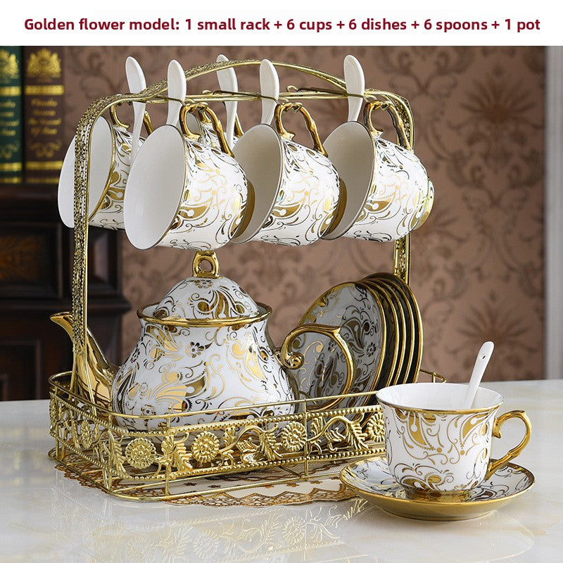 Decorative tea set with gold and white design on a marble surface.