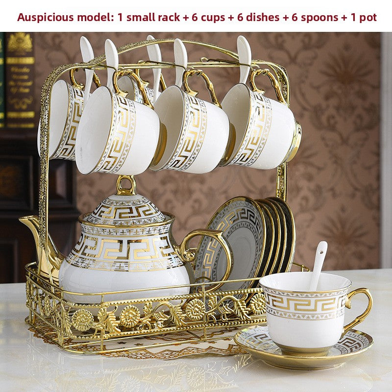 Decorative ceramic tea set with gold accents on a marble surface.