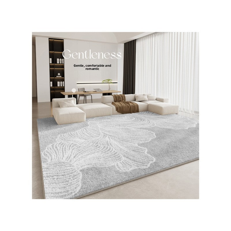 Modern living room with a large gray rug featuring white floral patterns, 'Gentleness' text, and minimal decor.