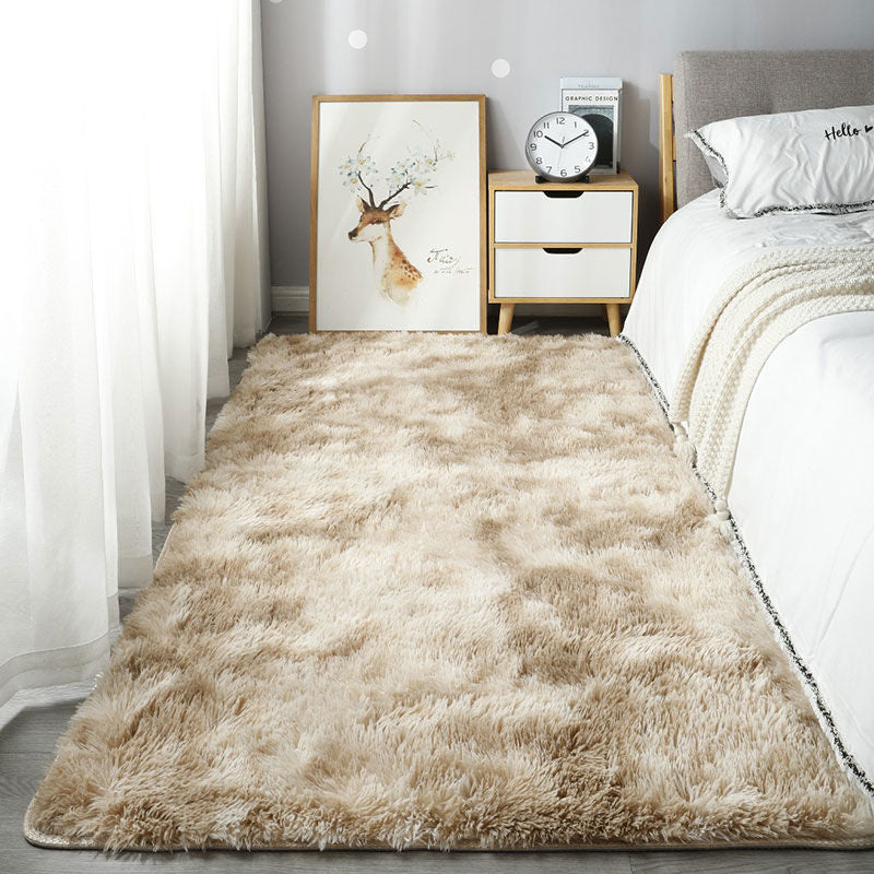 Beige rug in a bedroom with a bed, nightstand, and wall art.