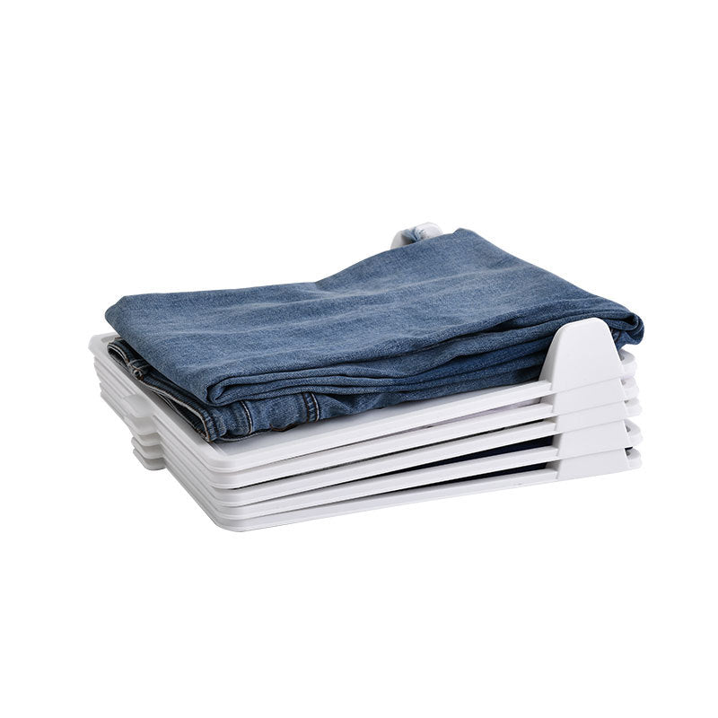 Folded blue jeans on a white storage rack against a white background