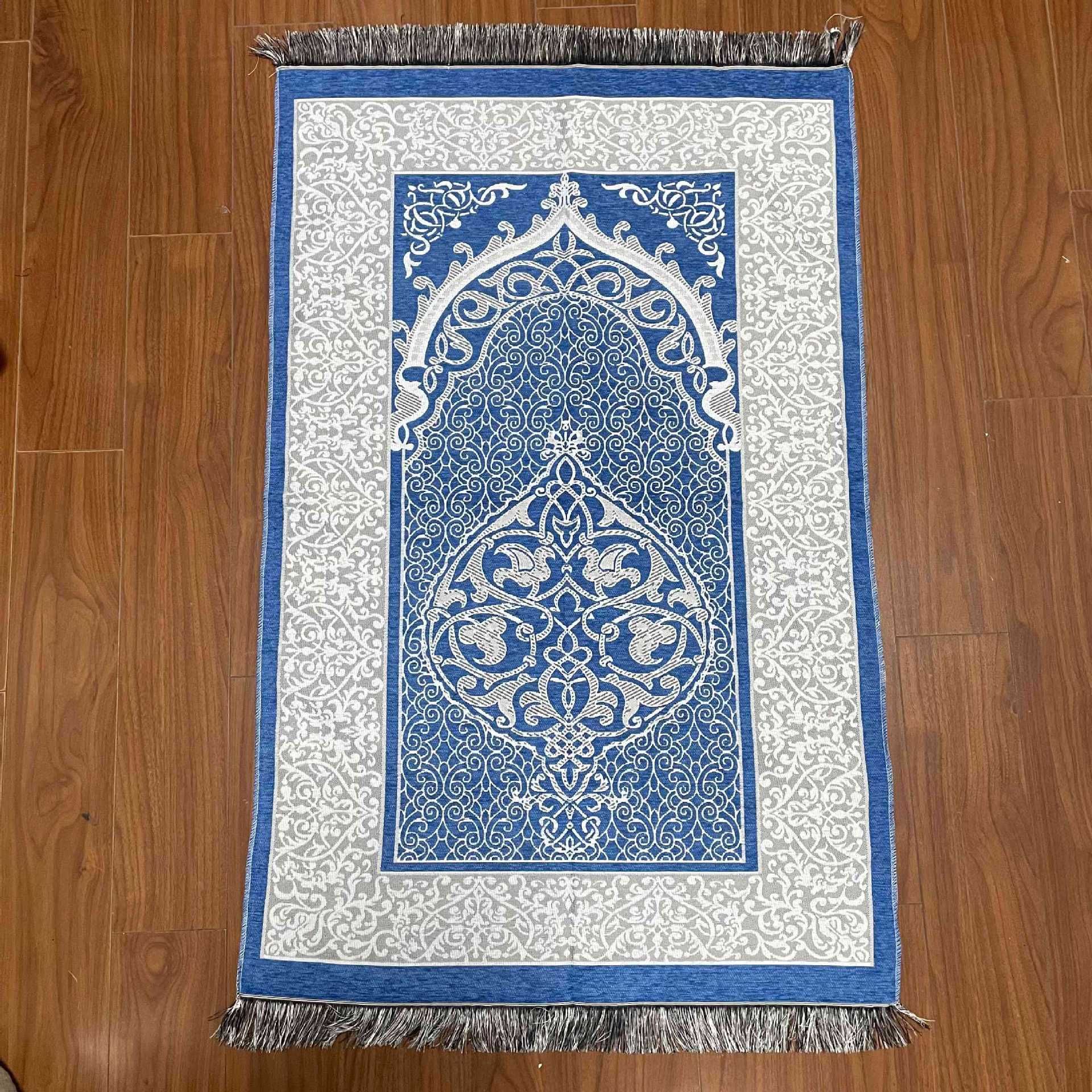 Decorative prayer mat with intricate blue and white design on a wooden floor