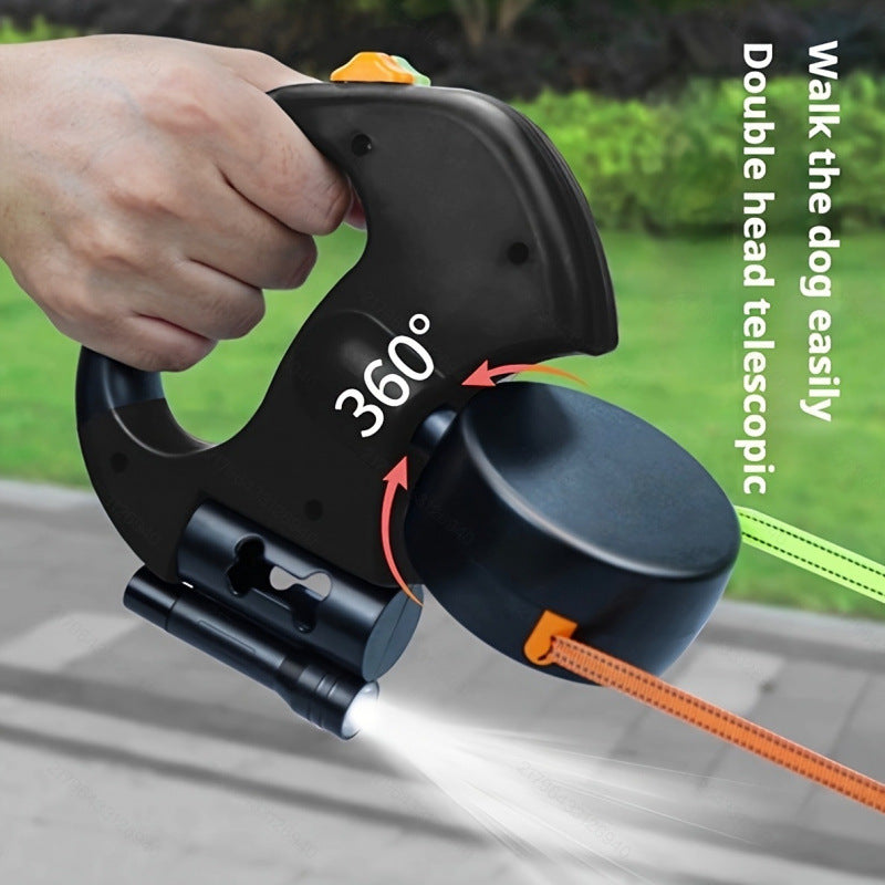 Hand holding a black and orange leash holder with a 360-degree design, on a blurred outdoor background.