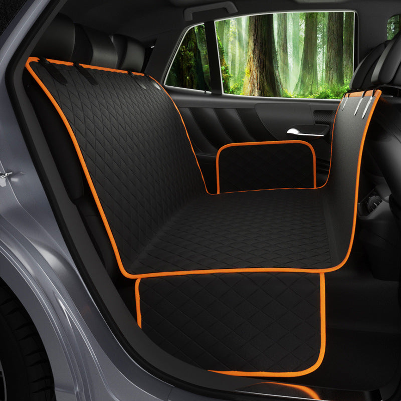 Car seat cover with orange trim inside a vehicle with a forest view outside.
