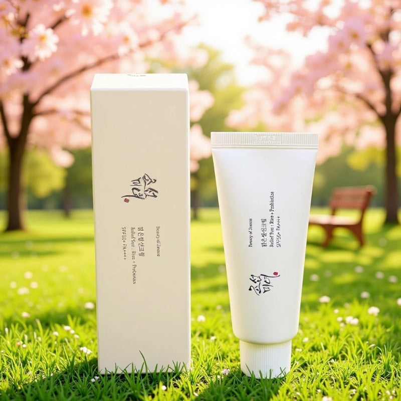 Skincare product with packaging on grass and cherry blossom trees in the background